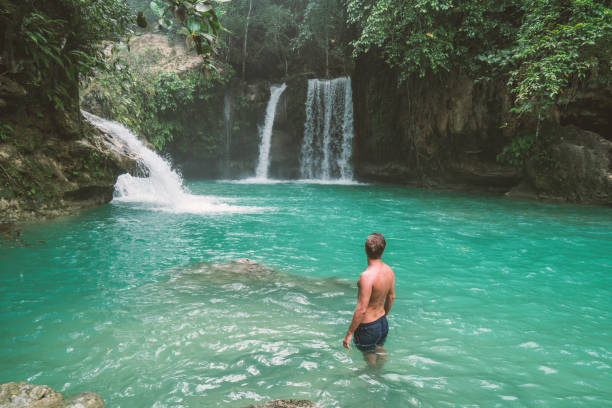istock Travel man contemplating beautiful waterfall in the Philippines 930725738