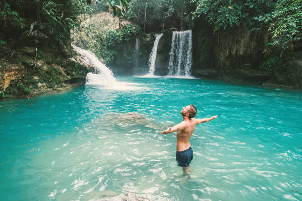 istock Young man embracing beautiful waterfall in the Philippines 930729210