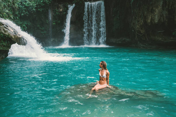 istock Young woman contemplating beautiful waterfall 930729538