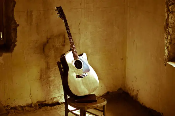 Photo of An old flamenco guitar abandoned in the ruins of an old house