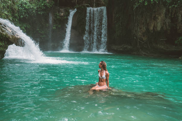 istock Young woman contemplating beautiful waterfall 930729794