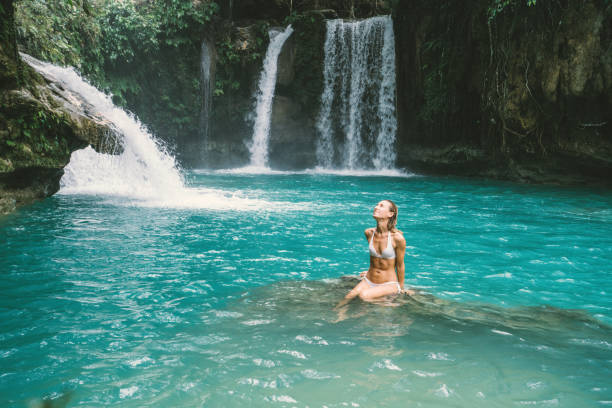 istock Young woman contemplating beautiful waterfall 930730142