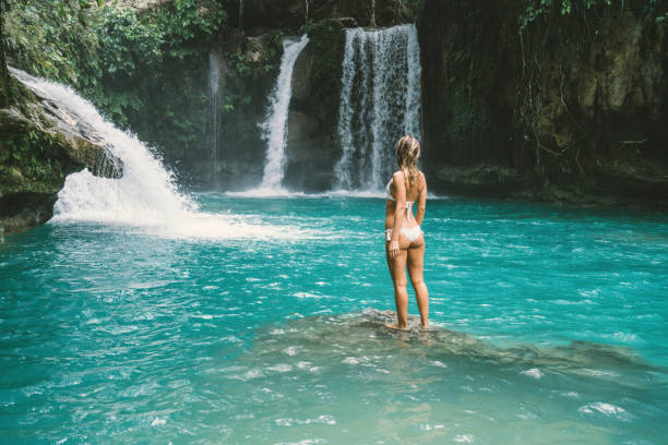istock Young woman contemplating beautiful waterfall 930730252