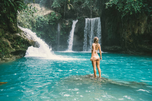 istock Young woman contemplating beautiful waterfall 930730388