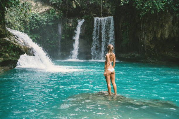 istock Young woman contemplating beautiful waterfall 930730788