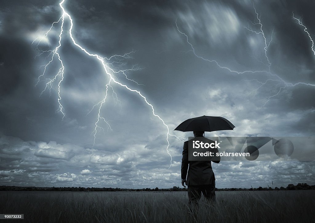 Mann in schwarzer Anzug mit einem schwarzen Regenschirm in einem Sturm - Lizenzfrei Gewitter Stock-Foto