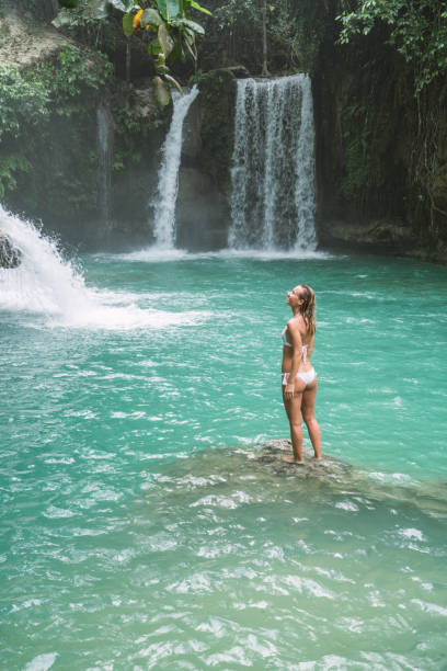 istock Young woman contemplating beautiful waterfall 930733090
