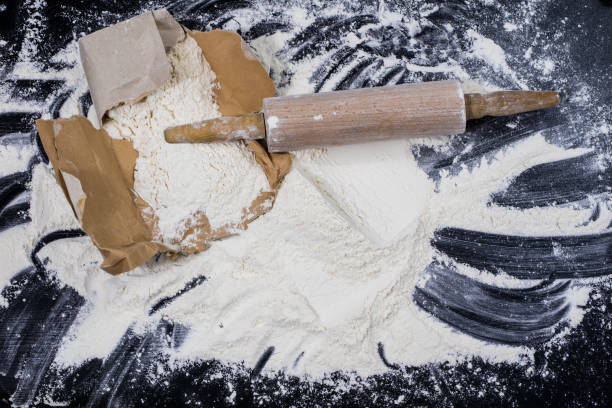 istock Flour and rolling pin for kneading the dough on the kitchen table. Accessories and kitchen products. Black table top. 930733490