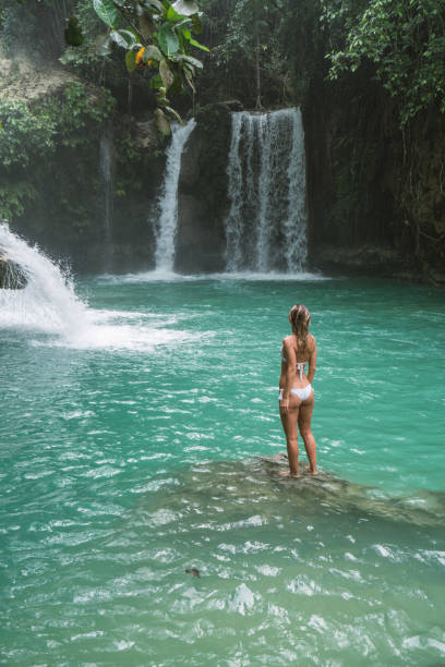 istock Young woman contemplating beautiful waterfall 930733514