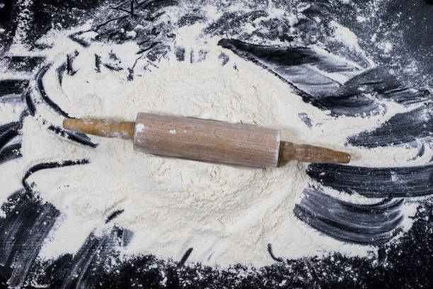 istock Flour and rolling pin for kneading the dough on the kitchen table. Accessories and kitchen products. Black table top. 930733650