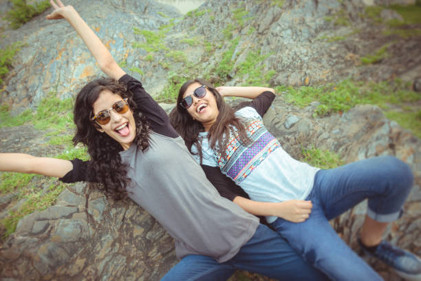 istock Happy female friends lying down on rock and having fun. 930736090