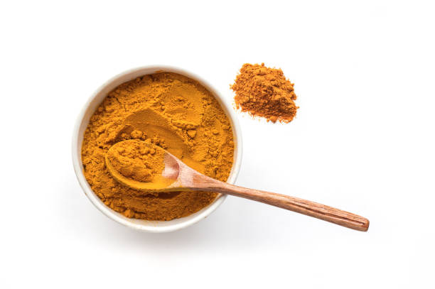 Isolated turmeric powder and wooden spoon. Top view. stock photo