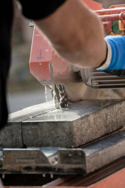 istock Workman using an angle grinder to cut a concrete block in a rear view 930755636
