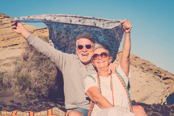 happy senior couple outdoor playing with the wind