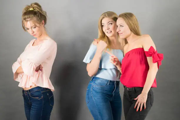 Photo of Woman being gossiped by two females