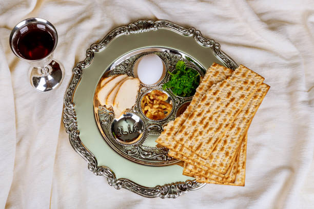istock Passover background with wine bottle, matzoh, egg and seder plate 930769190