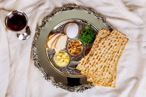 Photo of Pesah celebration Passover holiday. Traditional pesah plate text in hebrew: Passover, egg,