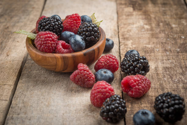 istock Blueberries and raspberries bowl on wooden table 930771996