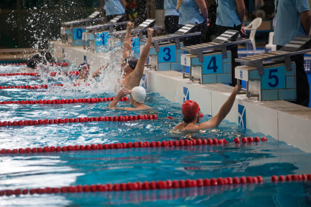 Young woman swimming in a race, back stroke.