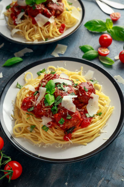 istock Spaghetti pasta meatballs with tomato sauce, basil, herbs parmesan cheese on dark background 930776740