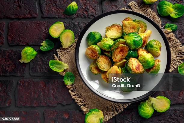 Caseros Coles De Bruselas Asadas Con Sal Pimienta En Una Vieja Mesa De Piedra Rústica Foto de stock y más banco de imágenes de Col de Bruselas