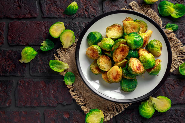 Homemade Roasted Brussel Sprouts with Salt, Pepper on a old stone rustic table Homemade Roasted Brussel Sprouts with Salt, Pepper on a old stone rustic table brussels sprout stock pictures, royalty-free photos & images