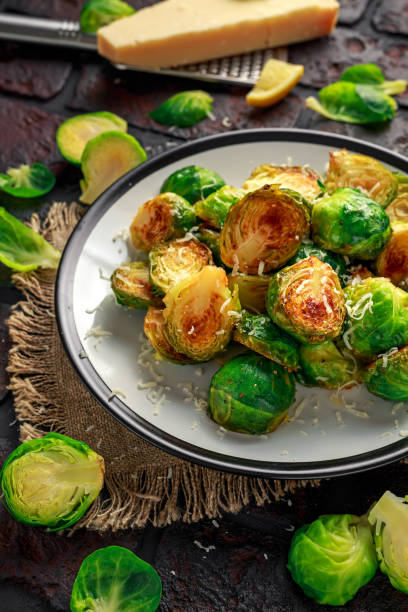 istock Homemade Roasted Brussel Sprouts with Parmesan cheese, lemon, Salt, Pepper on a old stone rustic table 930776820