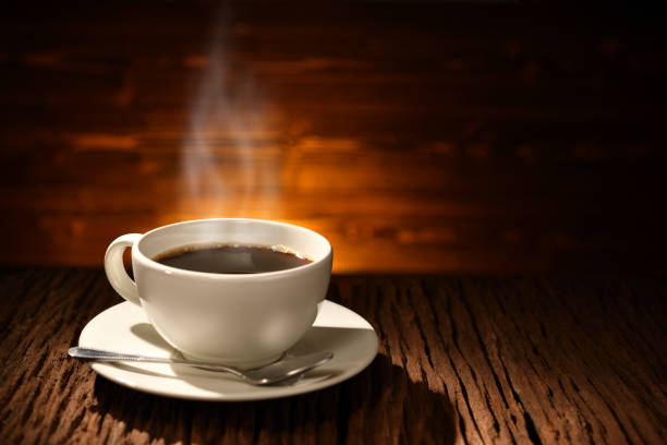 istock Cup of coffee with smoke on old wooden background 930781504