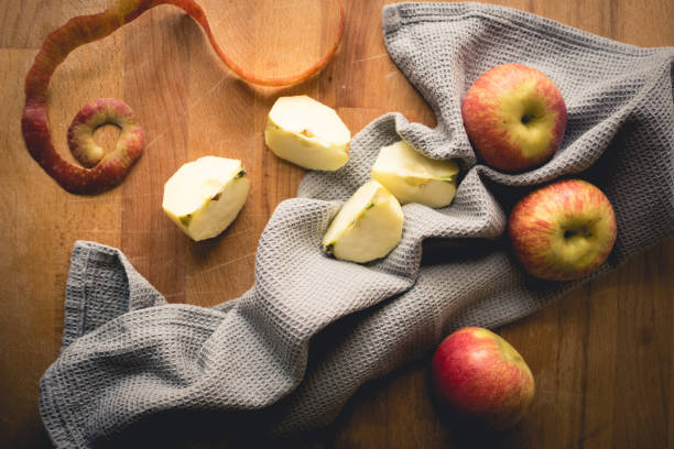 istock Top view of apples on a wooden chopping board with a grey kitchen cloth. 930788976