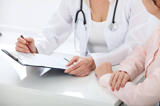 istock Female doctor holding application form while consulting patient at hospital 930792368