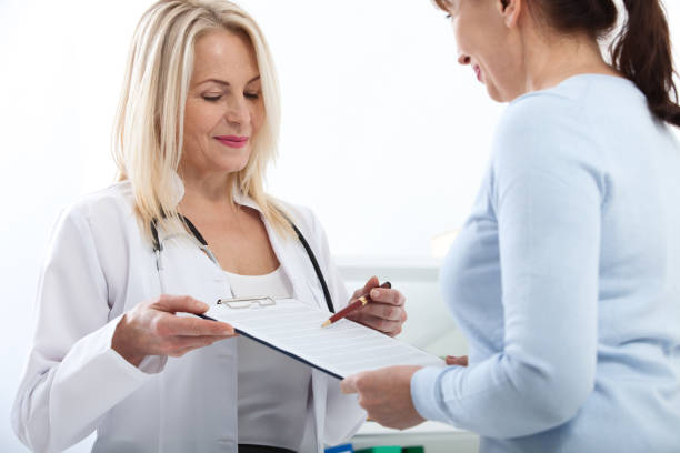 istock Female doctor holding application form while consulting patient at hospital 930792438