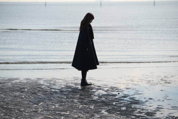 A woman looking at the sky on the coast