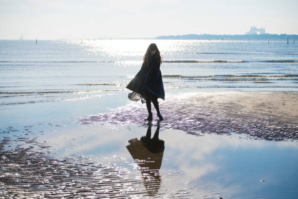 A woman looking at the sky on the coast
