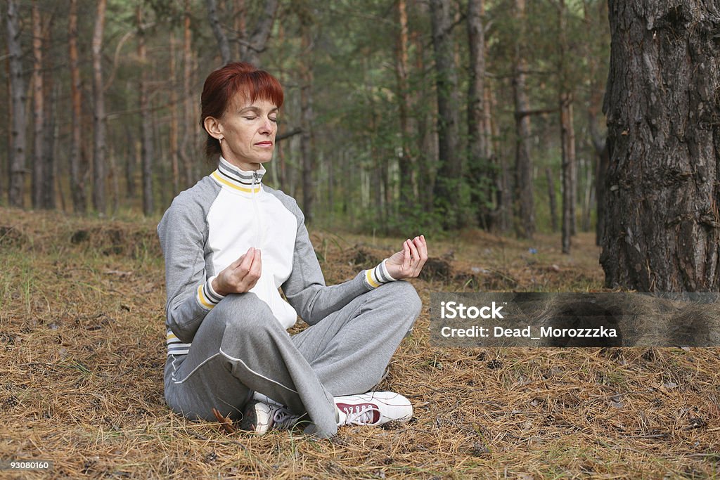 Media edad mujer haciendo yoga ejercicio en el bosque - Foto de stock de Actividades y técnicas de relajación libre de derechos