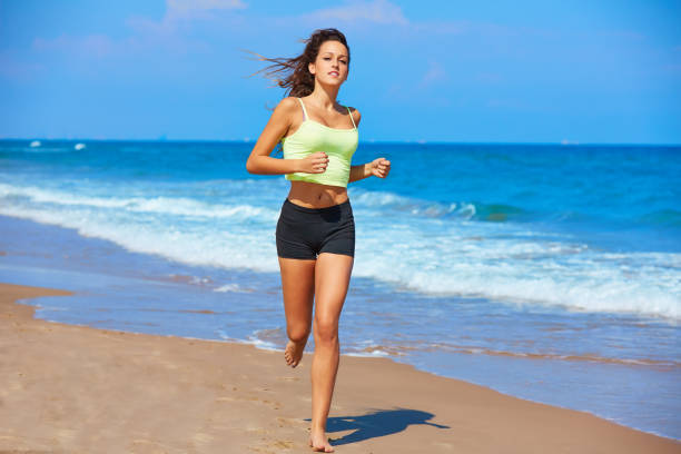 istock Beautiful brunette girl running in a summer beach 930805906