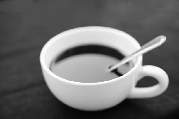 istock White cup of black coffee on black background in black and white 930810002