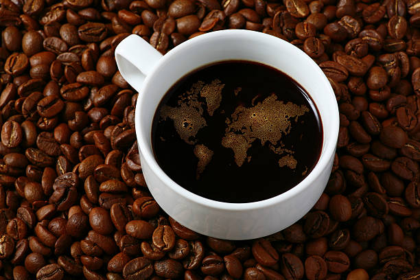 A cup of black coffee on top of whole coffee beans stock photo
