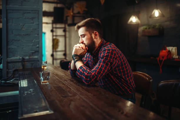istock Man sitting at the bar counter and drink alcohol 930820914