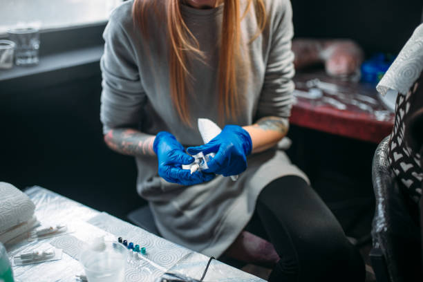 istock Female tattooist prepares tattoo machine 930823598