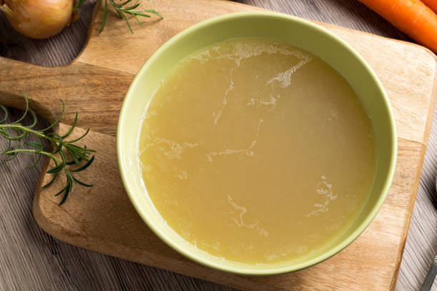 istock Chicken stock in a green soup bowl, top view 930842034