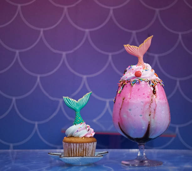 Mermaid cupcake and mermaid rainbow milkshake, soft focus stock photo