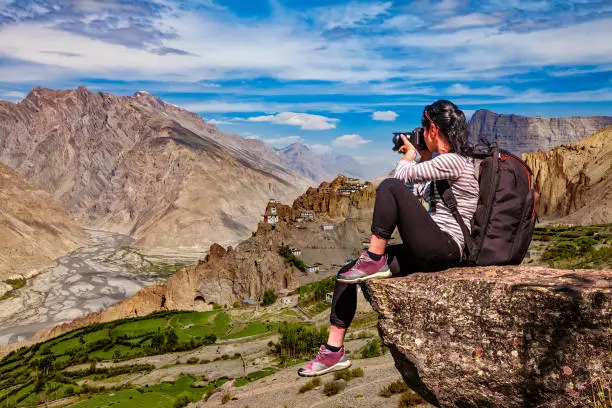 Dhankar gompa. Spiti Valley, Himachal Pradesh, India. Nature photographer tourist with camera shoots while standing on top of the mountain.