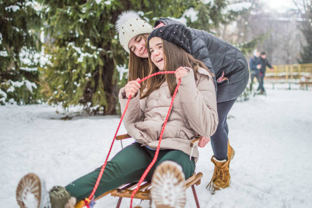 istock Sister twins having fun on snow 930855316