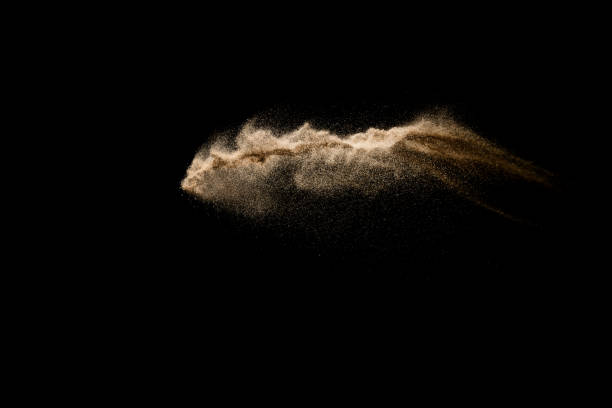 istock Abstract sand cloud. Golden colored sand splash agianst dark background. Yellow sand fly wave in the air. Sand explode on black background ,throwing freeze stop motion. 930860988