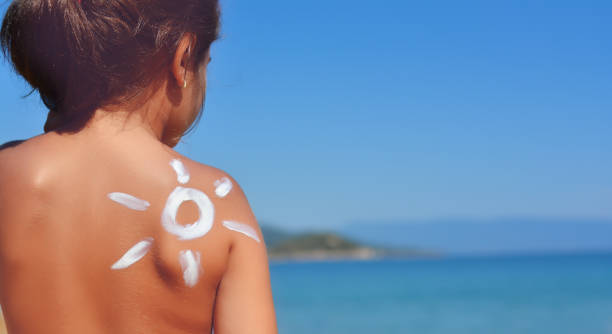 istock Young girl with sun protector cream at her shoulder on the beach 930864090