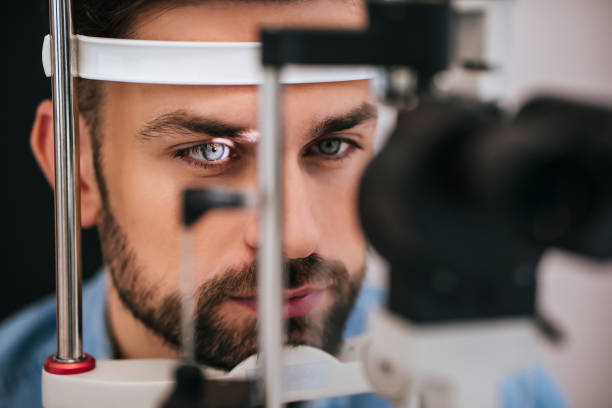 Patient in ophthalmology clinic Handsome young man is checking the eye vision in modern ophthalmology clinic. Patient in ophthalmology clinic glaucoma photos stock pictures, royalty-free photos & images