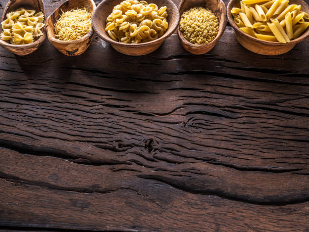 istock Different pasta types in wooden bowls on the table. 930864262