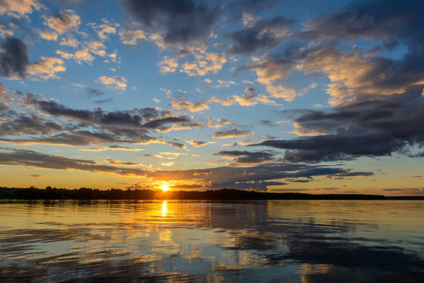 istock Sunset over water, with clouds and beautiful blue sky 930864780