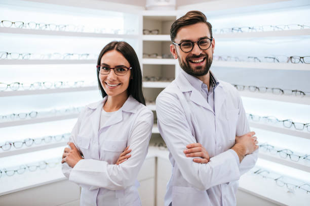 medici in clinica oftalmologia - smiling women glasses assistance foto e immagini stock