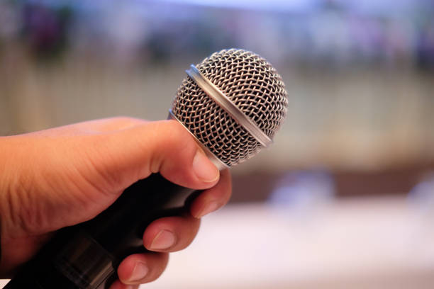 istock Close up of a man holding microphone - public speaking, conference, reportage 930868514